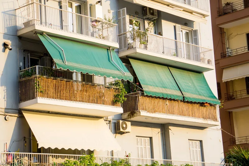 Ein gemütlicher Balkon im Sommer mit einer ausgefahrenen Klemmmarkise, die angenehmen Schatten spendet.