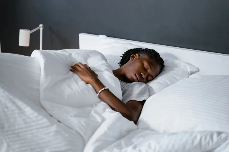 Eine friedliche Schlafzimmeratmosphäre mit einem bequemen Bett, symbolisiert erholsamen Schlaf und Wohlbefinden.