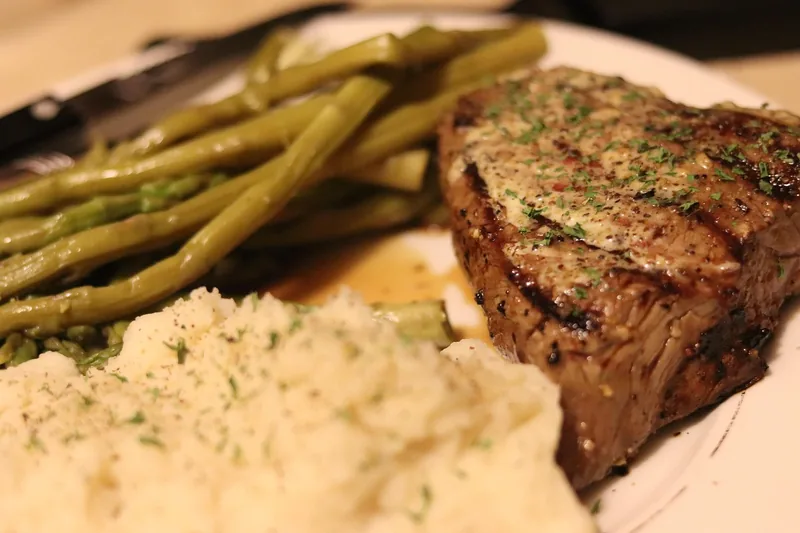 Ein appetitlich angerichtetes, perfekt gegrilltes Steak mit Beilagen, zubereitet mit dem Kontaktgrill.