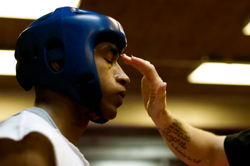 Eine Person beim Anlegen eines Box-Kopfschutzes, bereit für sicheres Training und Sparring.