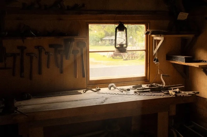 Eine atmosphärische Szene in einer Holzwerkstatt mit fertigen Holzprojekten und Werkzeugen im Hintergrund.