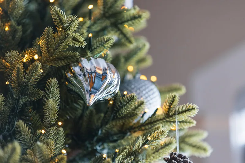 Nahaufnahme der detailreichen PE-Nadeln eines künstlichen Weihnachtsbaums, die Echtheit simulieren.