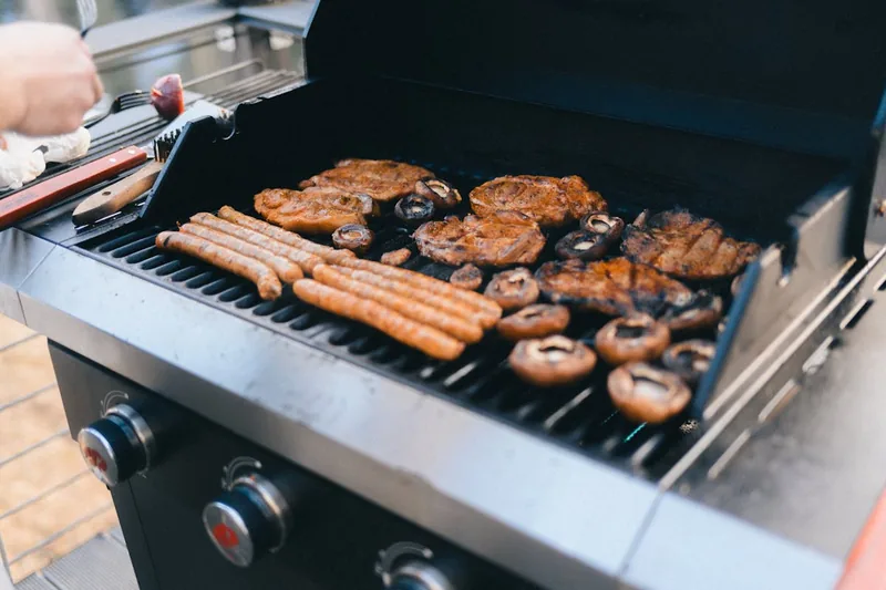 Ein glänzender, moderner Gasgrill steht auf einer Terrasse, bereit für den Einsatz und perfekt in Szene gesetzt.
