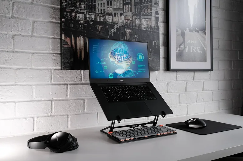 Aufgeräumtes Home-Office mit Laptop auf einem Ständer, betont einen modernen und effizienten Arbeitsplatz.