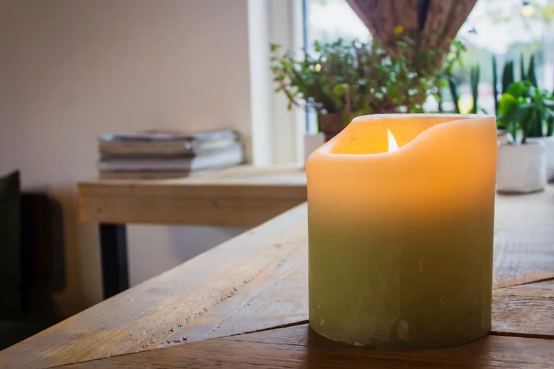 Ein warm beleuchtetes Wohnzimmer mit mehreren LED-Kerzen, die eine entspannte und einladende Atmosphäre schaffen.