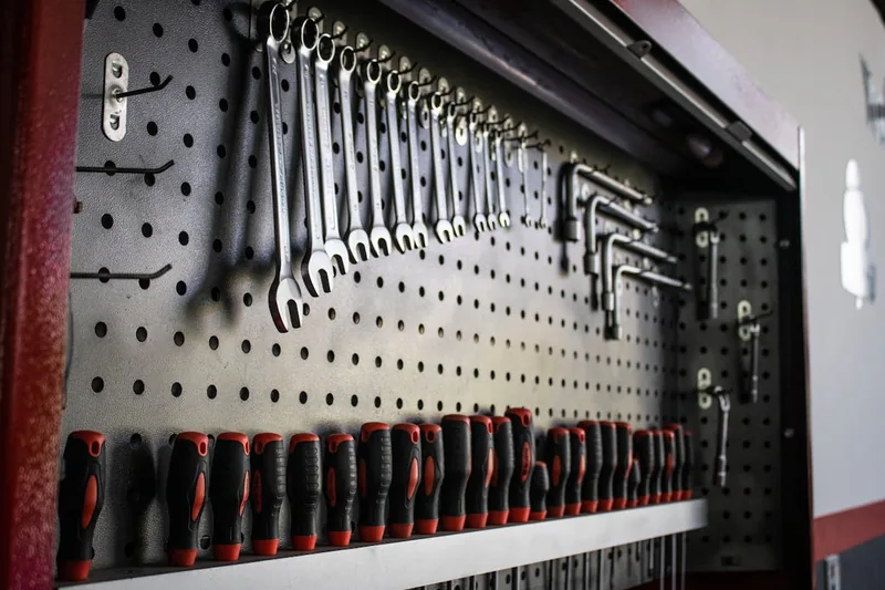 Eine neue, unbestückte Lochplatte aus Metall für die Werkstatt, sauber und bereit zur Montage.