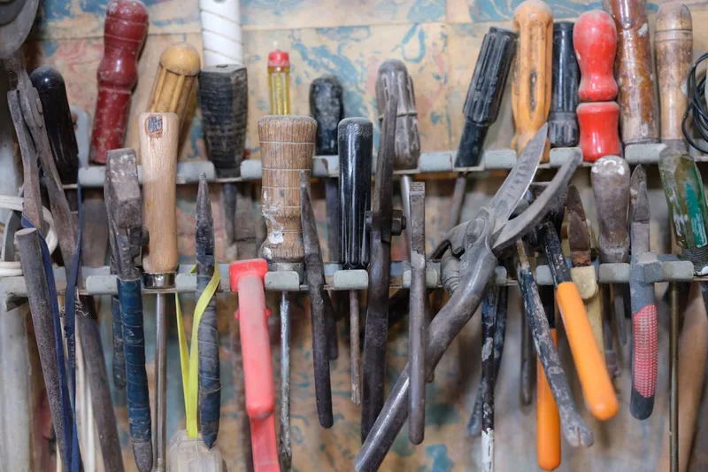 Ein aufgeräumter Arbeitsbereich mit mehreren Lochplatten an der Wand, übersichtlich mit Werkzeug.
