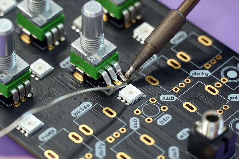 Ein moderner Lötkolben liegt auf einem neutralen, hellen Hintergrund, bereit für präzise Elektronikarbeiten.