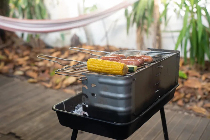 Ein gedeckter Tisch auf einer Terrasse mit fertig gegrilltem Essen und sommerlicher Atmosphäre.