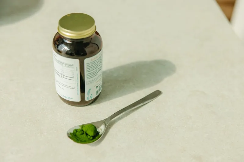 Nahaufnahme von feiner Heilerde in einer Verpackung und einem Löffel mit Pulver.