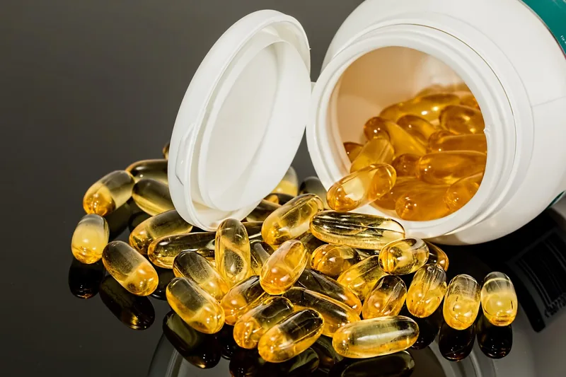 Eine Hand nimmt eine Lycopin-Kapsel aus der Dose, symbolisierend die tägliche Einnahme für diverse Nutzertypen.