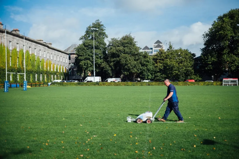 Eine Person mäht den Rasen mit einem kabellosen Akku-Rasenmäher, der einfach und leise durch den Garten gleitet.