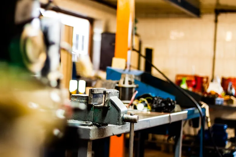 Ambiente einer modernen Metallwerkstatt mit verschiedenen Maschinen, Werkzeugen und fertigen Metallteilen.