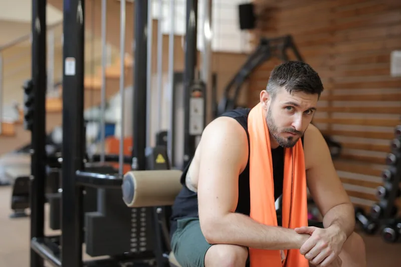 Eine Person trocknet sich nach dem Sport mit einem kompakten Mikrofaser-Handtuch ab.
