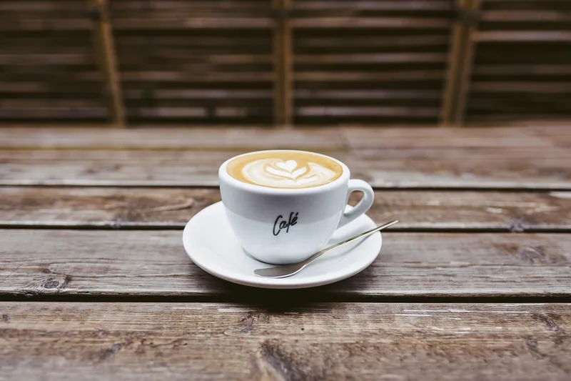 Ein kunstvoll verzierter Latte Macchiato mit perfektem Milchschaum auf einem Küchentresen.