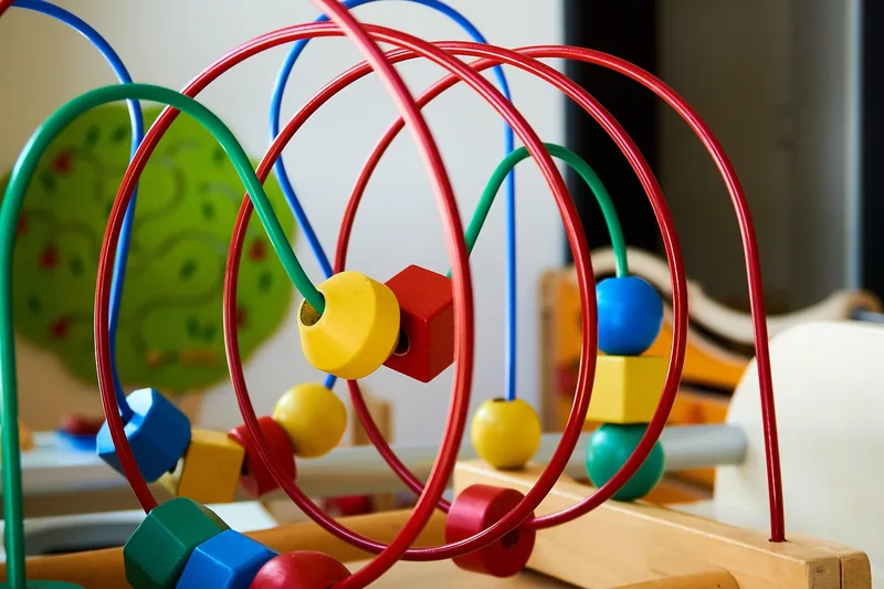 Ein helles Kinderzimmer mit verschiedenen Motorikspielzeugen, schafft eine anregende Lernumgebung.