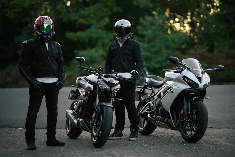 Hochwertige schwarze Motorrad-Lederkombi, sorgfältig auf einem Bügel präsentiert, bereit für die nächste Fahrt.