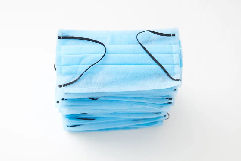 Nahaufnahme einer blauen medizinischen Mundschutz Maske auf weißem Hintergrund, sauber und steril.