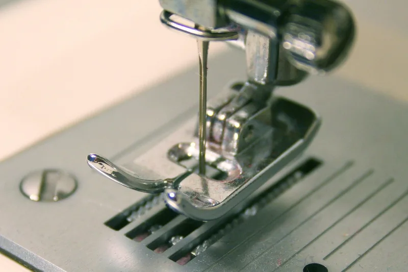 Eine moderne Nähmaschine in Nahaufnahme auf weißem Hintergrund, bereit für kreative Projekte.