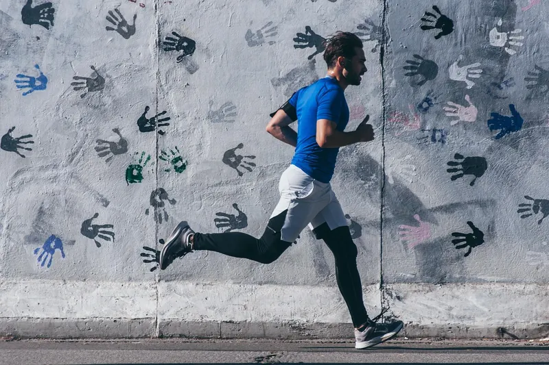 Füße eines Läufers in modernen Laufschuhen auf einer Straße, während des Joggens, Fokus auf die Bewegung.