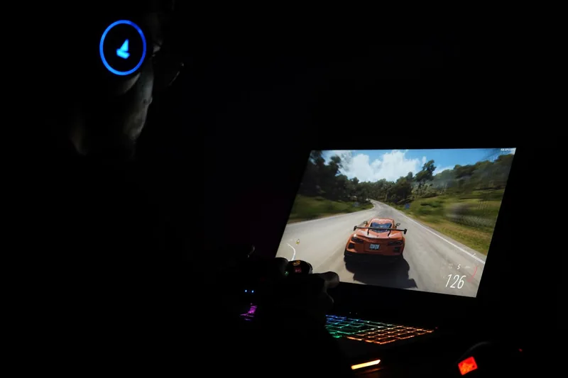 Eine Person spielt auf einem Gaming Notebook, Hände an Tastatur und Maus, konzentriert auf das immersive Spielerlebnis.