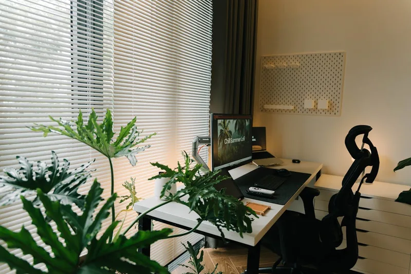 Ein aufgeräumter Home-Office-Schreibtisch mit Monitor, Tastatur und Zubehör, ideal für effizientes Arbeiten.
