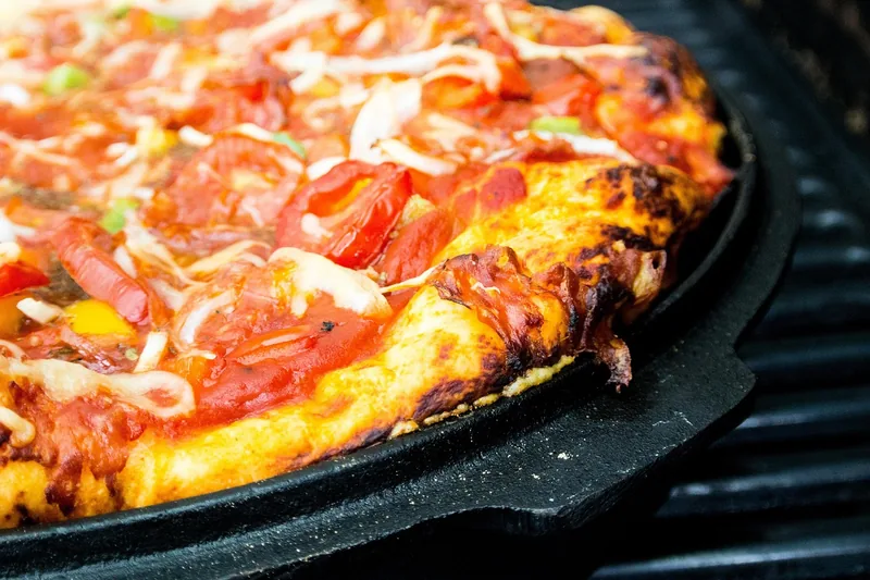Ein hochwertiger Pizzaaufsatz für den Gasgrill, klar erkennbar, bereit für authentische Steinofenpizza-Ergebnisse.