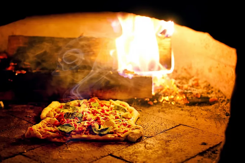 Moderner Pizzaofen freigestellt im Vordergrund, bereit für köstliche Pizzen zu Hause oder im Garten.