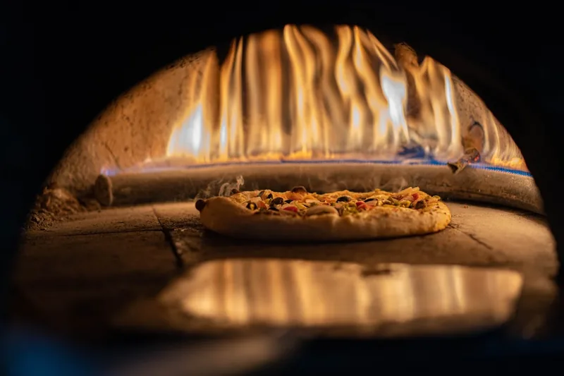 Nahaufnahme des feuerfesten Pizzasteins im Inneren des Ofens, wichtig für knusprigen Boden.