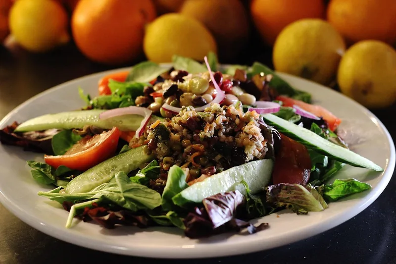 Eine Person rührt Quinoa in einem Topf auf dem Herd, für eine frische und gesunde Mahlzeit.