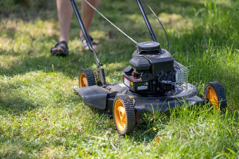 Nahaufnahme der scharfen Klingen eines Rasenmähers, bereit für präzisen Rasenschnitt im Garten.