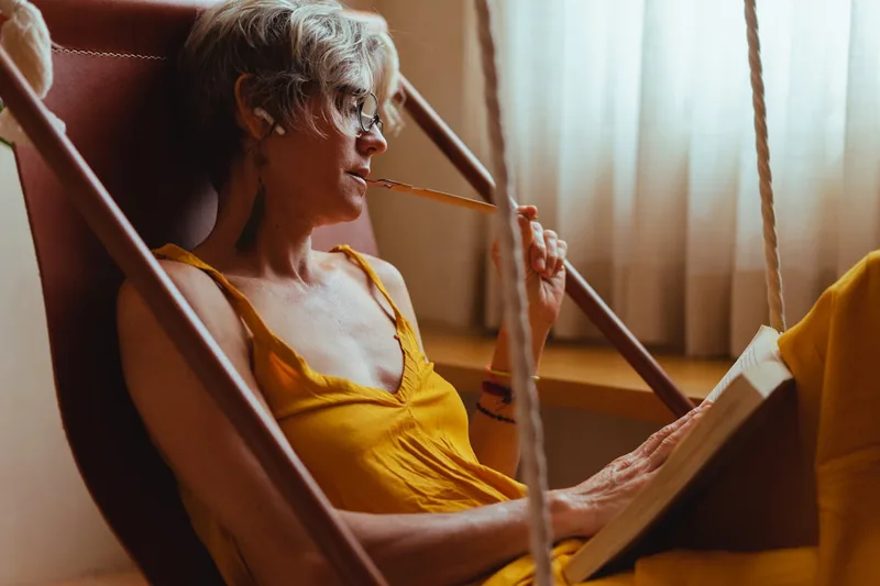 Eine Person entspannt in einem ergonomischen Relaxsessel, genießt Komfort beim Lesen eines Buches.
