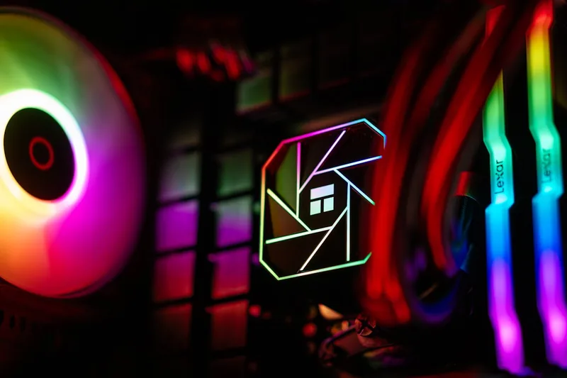 Eine Hand, die vorsichtig einen leuchtenden RGB-Lüfter in das Gehäuse eines Gaming-PCs einbaut.