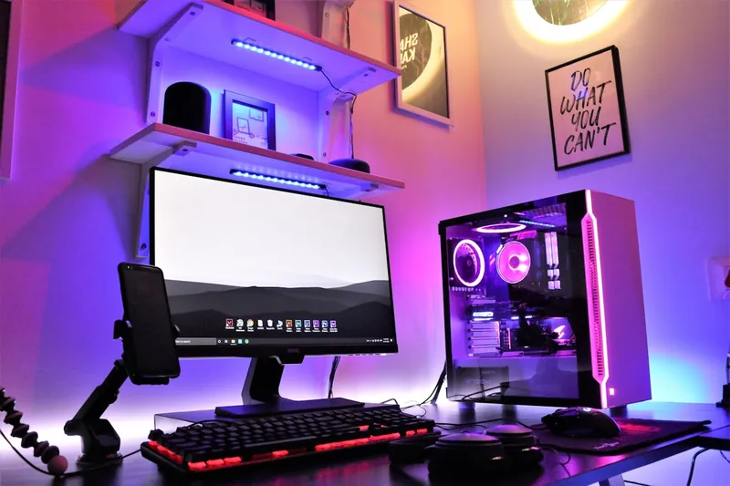 Ein beeindruckendes Gaming-Setup mit einem leuchtenden PC, dessen RGB-Lüfter für eine farbige Atmosphäre sorgen.