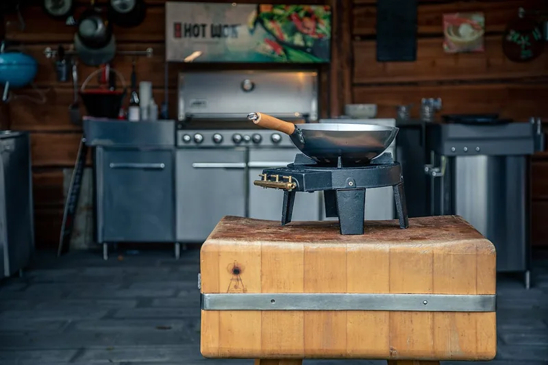 Ein hochwertiger Outdoor-Gasgrill aus Edelstahl in modernem Design, auf einer Terrasse stehend.