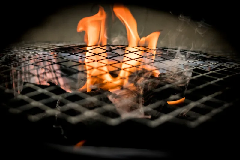Nahaufnahme der gusseisernen Grillroste eines Gasgrills, bereit zum Braten von Speisen.