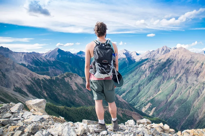 Atemberaubende Berglandschaft mit einem Rucksack im Vordergrund, symbolisiert Freiheit und Abenteuer.