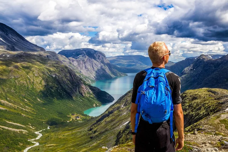 Ein Wanderer mit einem 35-Liter-Rucksack genießt die Aussicht auf einem sonnigen Bergpfad.