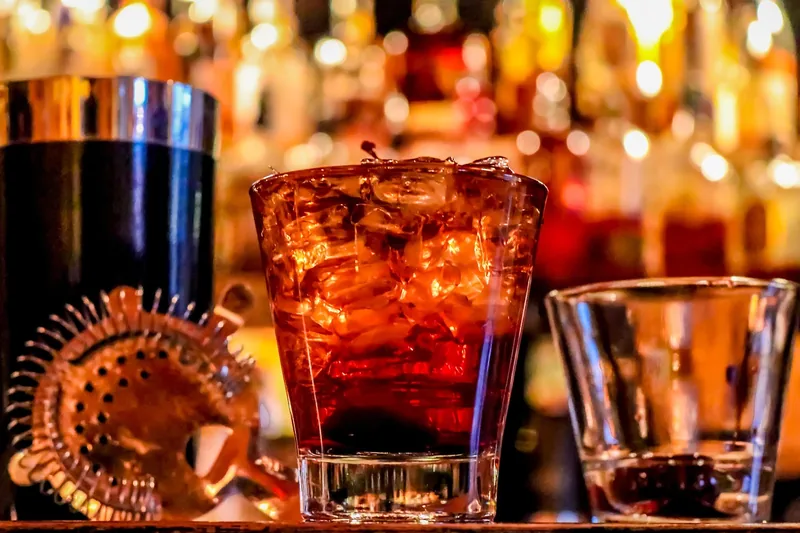 Person mixt einen Rum-Cocktail mit frischen Zutaten