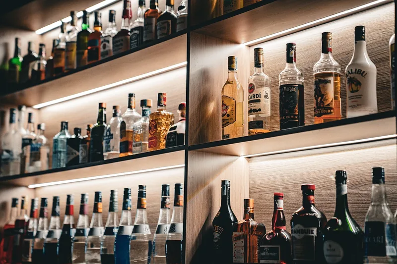 Gedimmte Bar-Atmosphäre mit Rum-Flaschen und Gläsern