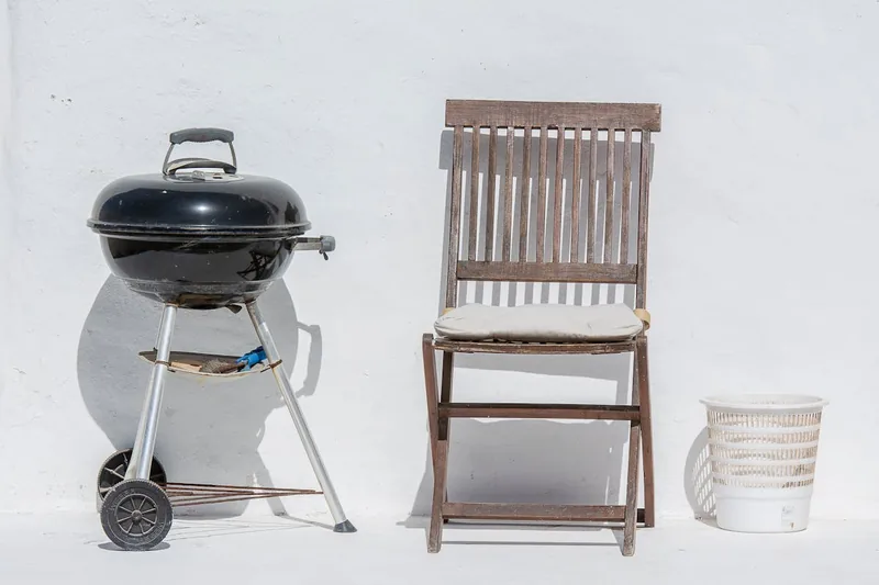 Ein neuer, unbenutzter Rundgrill aus Metall auf einem schlichten Hintergrund, bereit für den Garten.