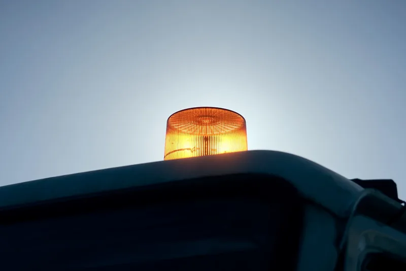 Eine nächtliche Baustellen- oder Pannenszene mit Fahrzeugen und aktiven Rundumleuchten für Sicherheit.