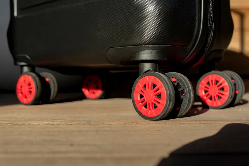 Detailaufnahme des robusten Rollensystems eines Koffers, das für reibungsloses Reisen sorgt.