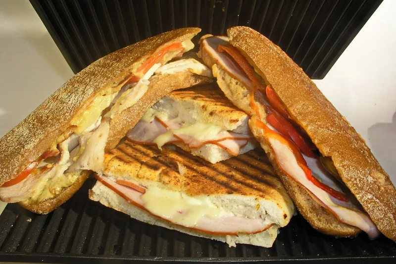 Nahaufnahme der antihaftbeschichteten Heizplatten eines Sandwichmakers, offen und bereit zur Benutzung.
