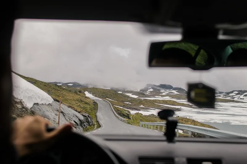 Eine klare Autoscheibe in einer winterlichen Morgenlandschaft, bereit für die Fahrt.