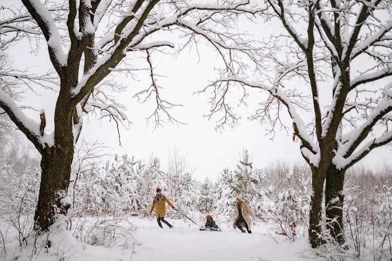 Verschneite Winterlandschaft mit spielenden Kindern, warme Kinder Schneehandschuhe schützen vor Kälte.