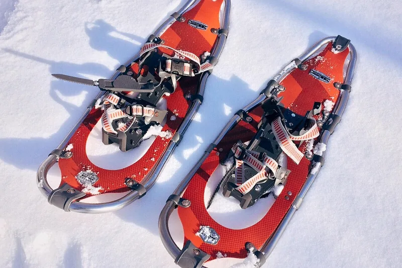 Ein Paar moderne Schneeschuhe als Produktfoto, isoliert auf hellem Hintergrund.