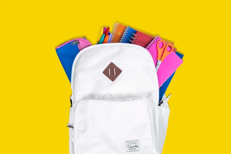 Ein moderner, leerer Schulrucksack in einem klaren Studio-Setting, von vorne gezeigt.