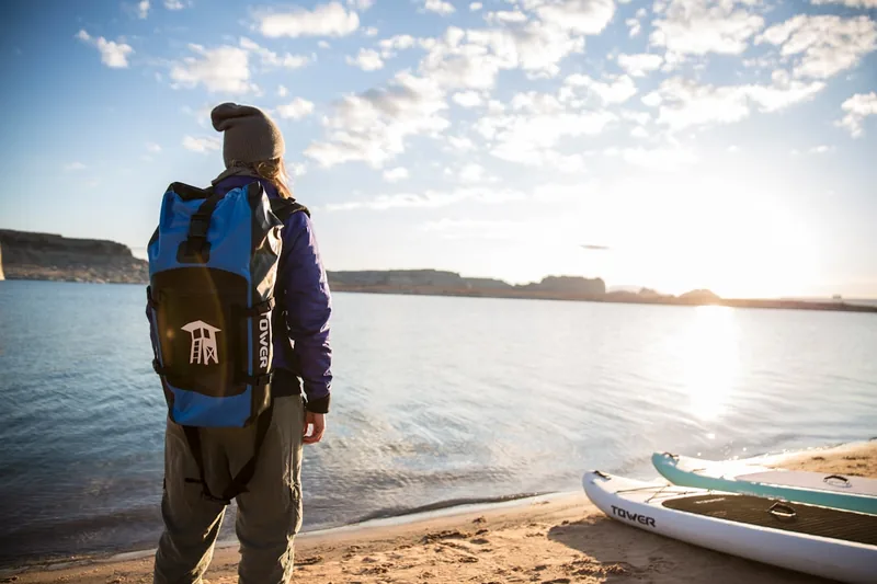 Eine Person trägt einen geräumigen Schwimmrucksack am Beckenrand, gefüllt mit Schwimmausrüstung.
