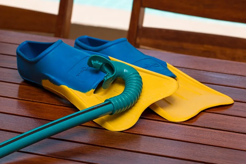 Eine organisierte Schwimmausrüstung am Poolrand, die den Einsatz eines Schwimmrucksacks andeutet.